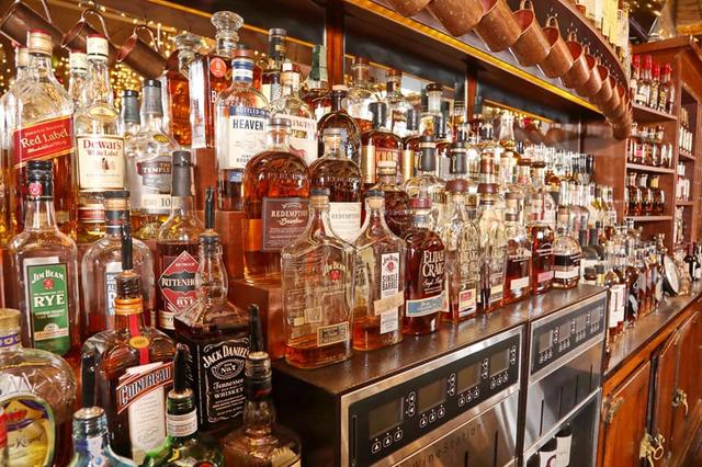 Bottles lining the backbar at the Community Restaurant, black and white
