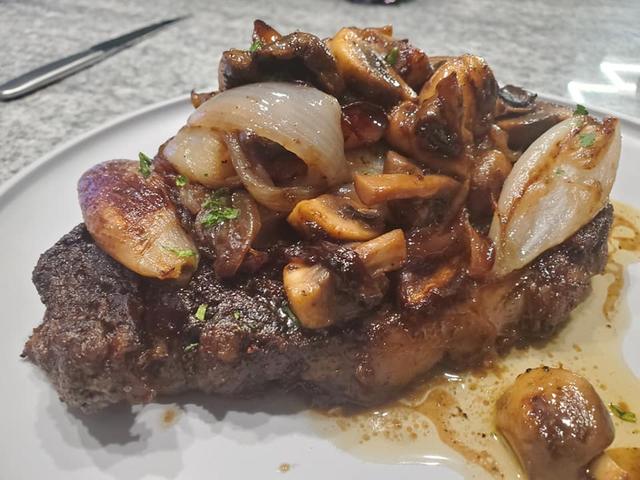 Steak topped with mushrooms and onions